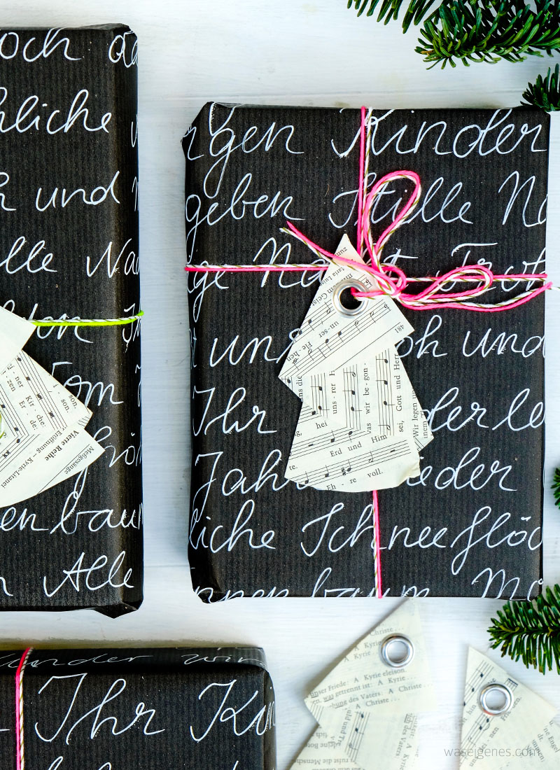 DIY Weihnachtsbaum Geschenkanhänger | aus den Seiten eines alten Gotteslobes falten, eine Öse einschlagen | schwarzes Geschenkpapier Handlettering, neon Garn | waseigenes.com DIY Blog