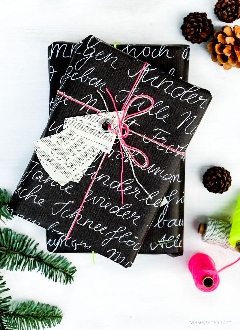 DIY Weihnachtsbaum Geschenkanhänger | aus den Seiten eines alten Gotteslobes falten, eine Öse einschlagen | schwarzes Geschenkpapier Handlettering, neon Garn | waseigenes.com DIY Blog
